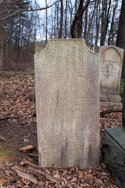 Worn gravestone, carving is difficult to decipher