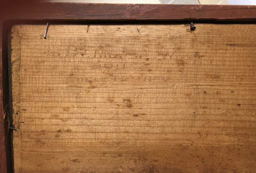 a flat piece of wood with words carved on it
