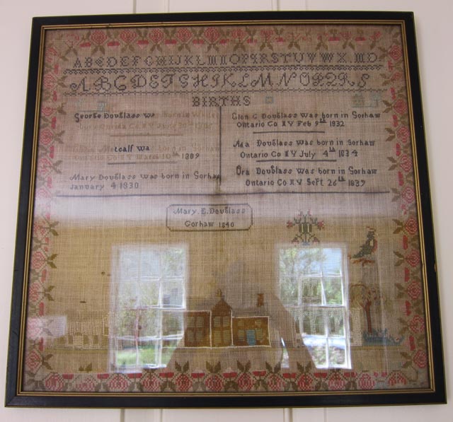 Framed embroidery sampler with birth and marriage dates of the Douglass family